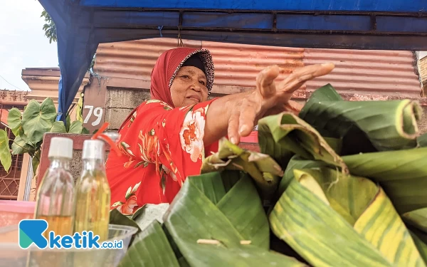 Foto Pedagang Bunga Tabur, Sukarmi (63) yang menggelar lapak dadakan di Tikungan Ngemplak, Sirnoboyo, Pacitan. (Foto: Al Ahmadi/Ketik.co.id)