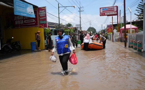 Foto Petugas saat membagikan nasi bungkus ke warga terdampak banjir. (Foto: Humas Pemkot Mojokerto)