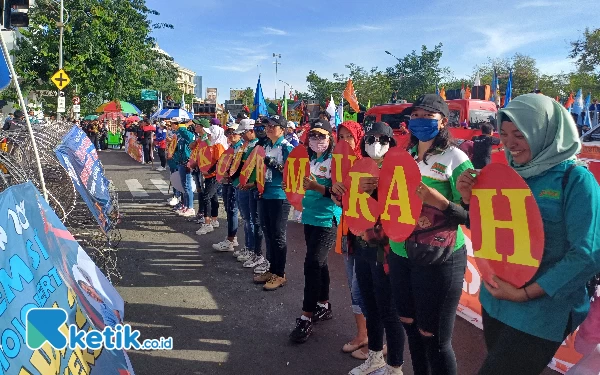 Thumbnail Salah satu pendemo dari buruh terlihat tersenyum saat menyuarakan keresahannya, Rabu (1/5/2024). (Foto: Khaesar/Ketik.co.id)