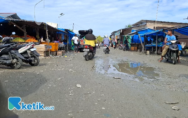 Thumbnail Jalan pasar bagian barat yang bergelombang dan penuh becek menyumbang pemandangan tak sedap di area barat pasar. Kondisi tersebut membuat para pengendara harus tetap hati-hati saat melintasinya. (Foto Mursal Bahtiar/Ketik.co.id) Jum'at, (3/5/2024)