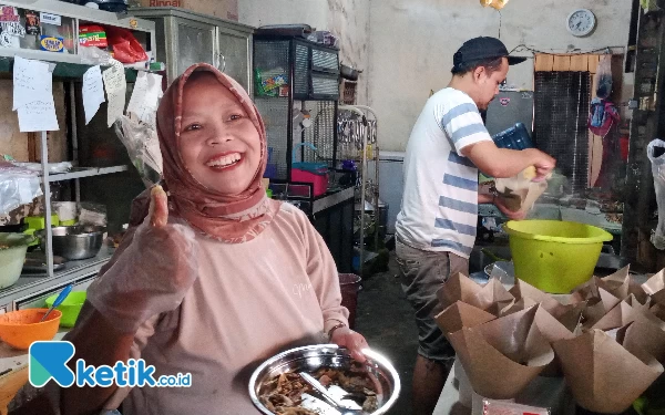 Foto Mbak Sih, Pemilik Warung Mbak Sih sedang menyiapkan nasi bungkus. (Foto: Sholeh/Ketik.co.id)