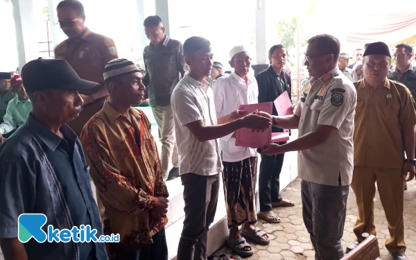 Foto Pj Bupati Bondowoso Bambang Soekwanto saat menyerahkan berkas kepada masyarakat yang telah memanfaatkan layanan (Ari Pangistu/Ketik.co.id)