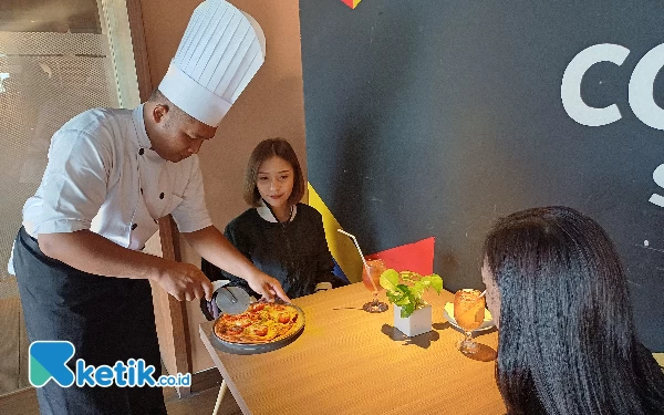 Foto Chef memotong langsung pizza rendang dihadapan pelanggannya, Kamis (23/5/2024). Foto: Khaesar/Ketik.co.id)