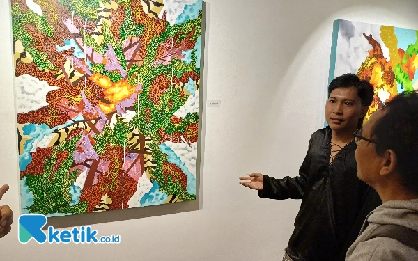 Foto Seniman asal Pekalongan Ageng Marhaendika menjelaskan arti dari lukisan dirinya, Sabtu (25/5/2024). (Foto: Khaesar/Ketik.co.id)