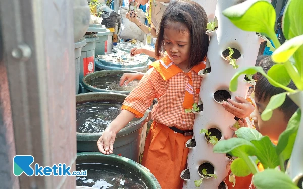 Foto Para peserta eduwisata saat memberikan makan ikan lele yang diternakan di drum. (Foto: Husni Habib/Ketik.co.id)