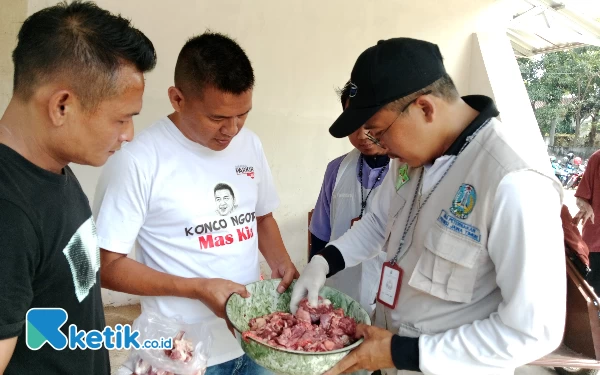 Foto drh Harris dari dinas Pertanian dan ketahanan pangan kota Madiun saat memeriksa daging hewan qurban didampingi mas kia