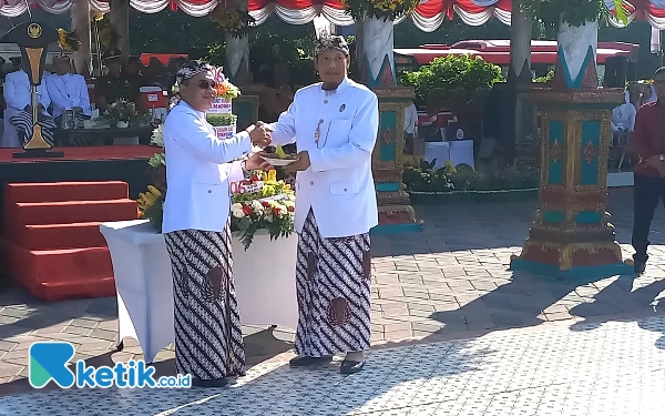 Foto Pj Bupati Eddy Supriyanto (kiri)serahkan potongan tumpeng ke ketua DPRD Andi Raya (foto : Kurniawan)