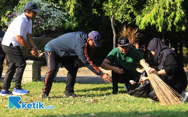 Foto Plt Bupati Sidoarjo H Subandi SH MKn memunguti sampah dedaunan dan kertas bersama Kepala Bappeda Heri Soesanto, Kepala Disporapar Sidoarjo, serta para ASN setelah senam bareng di Alun-Alun Sidoarjo Jumat pagi (21/6/2024). (Foto: Fathur Roziq/Ketik.co.id)