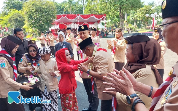 Thumbnail Pengalungan bunga kepada ketua Kwarcab Surabaya, Armuji oleh Cak Ning Cilik Surabaya. (Foto: Husni Habib/Ketik.co.id)