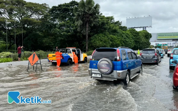 Thumbnail Petugas berjaga di Tol Soedijatmo yang tergenang banjir dan memberikan tanda agar pengendara berhati-hati (Foto: Kigaus/Ketik.co.id)