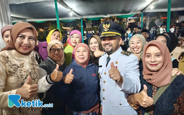 Foto Wakil Wali Kota Batu Mas Heli berfoto bersama masyarakat yang menunggu kedatangannya di Rumah Dinas, Jum'at 29 Februari 2025 malam. (Foto: Sholeh/Ketik.co.id)