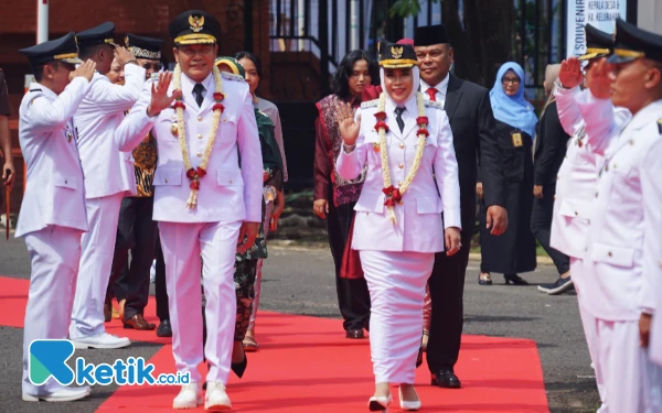 Foto Bupati Sidoarjo Subandi dan Wakil Bupati Sidoarjo Mimik Idayana diiringi keluarga berjalan dari pintu gerbang menuju Pendopo Delta Wibawa. (Foto: Kominfo Sidoarjo).