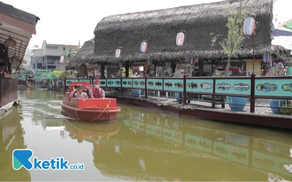 Foto Pengunjung sedang menikmati berkeliling Pasar Apung Museum Angkut dengan menaiki perahu (Foto: Sholeh/ketik.co.id)