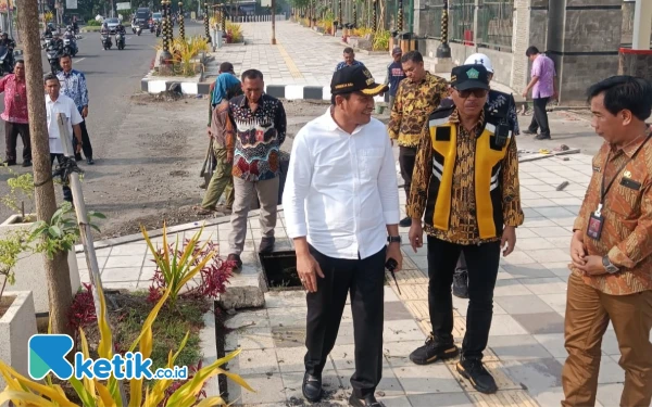 Foto Bupati Subandi berjalan di trotoar jalur pedestrian GOR Delta bersama kepala-kepala dinas. (Foto: Fathur Roziq/Ketik.co.id)
