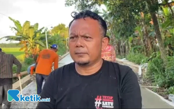 Foto Kepala Desa Kalipancur, Muhroji saat di wawancara di lokasi pembangunan rabat beton (Rohadi/ketik.co.id)