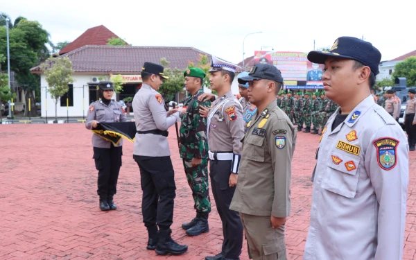 Foto Kapolres Jepara melakukan pemasangan pita kepada perwakilan personel sebagai simbol dimulainya Operasi Ketupat 2025, Jumat (21/3/2025) (Foto: Dok Humas Polres Jepara)