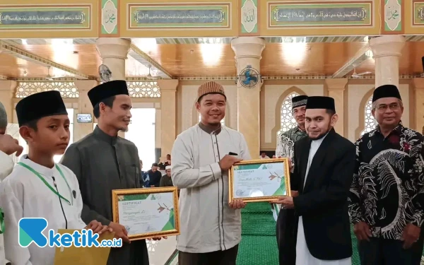 Foto Ketua Badan Baitul Mal Kabupaten Simeulue, Supriadi Menyerahkan Sertifikat Penghargaan kepada Guru Pembimbing Daurah Tahfidz Ramadan di Masjid Agung Tgk. Khalilullah, Sabtu 22 Maret 2025 (Helman/Ketik.co.id)