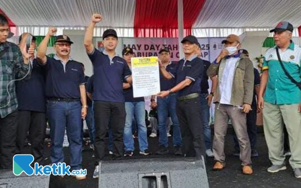 Foto Bupati Cilacap Syamsul Aulia Rachman didampingi Wakil Ketua DPRD Cilacap Suyatno foto bersama perwakilan buruh usai menandatangani Tritura. (Foto:Nani Eko/ketik.co.id)