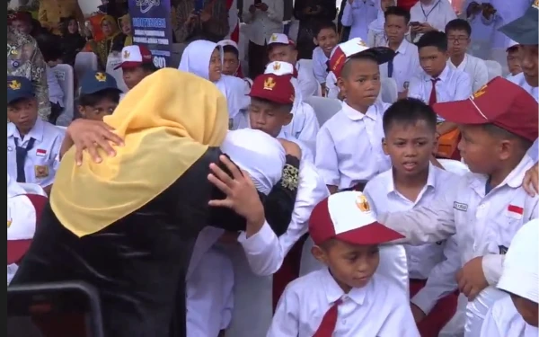Foto Gubernur Jatim Khofifah Indar Parawansa memeluk siswa di sela upacara memperingati Hari Pendidikan Nasional (Hardiknas) 2025 di Gedung Negara Grahadi di Surabaya, Jumat, 2 Mei 2025. (Foto Tangkapan Layar Kominfo MMC Jatim)