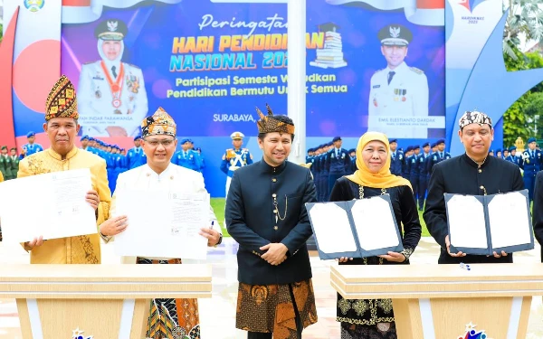 Foto Gubernur Jatim (kedua kanan) bersama Kepala Dinas Pendidikan Jatim Aries Agung Paewai (kedua kiri) menunjukkan lembar nota kesepahaman dan kesepakatan di sela Upacara Hardiknas di Gedung Negara Grahadi di Surabaya, Jumat, 2 Mei 2025. (Foto: Biro Adpim Pemprov Jatim)