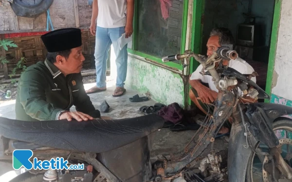 Foto Ketua Komisi D DPRD Sidoarjo Dhamroni Chudlori berbincang dengan Kakek Salamun tentang kondisi rumahnya yang rusak parah. (Foto: Fathur Roziq/Ketik.co.id)