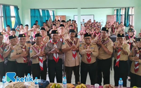 Foto Terlihat sebanyak puluhan peserta yang terdiri dari para guru SD dan penggiat Pramuka, mengenakan seragam lengkap Pramuka dengan syal merah putih, berpose kompak sambil membentuk simbol tangan khas Pramuka sebagai wujud semangat dan solidaritas.