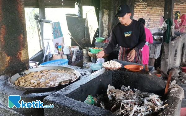 Foto Pekerja UMKM produsen tahu sedang menggoreng tahu dengan tungku pembakaran di Desa Tropodo, Kecamatan Krian, Sidoarjo. (Foto: Fathur Roziq/Ketik.co.id)