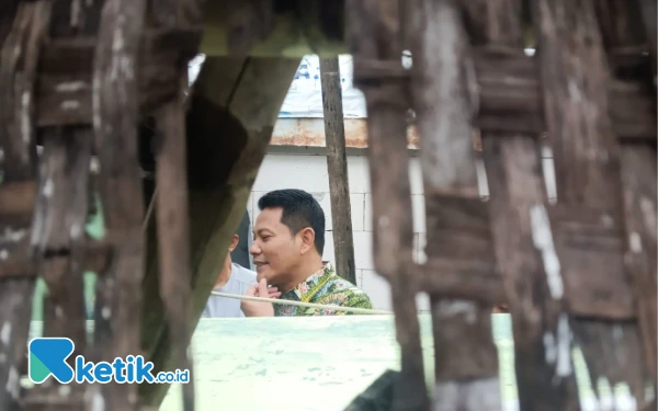 Foto Bupati Subandi melihat bagian dalam rumah Iswahyudi yang dindingnya dari bambu dan sudah rusak. (Foto: Fathur Roziq/Ketik.co.id)