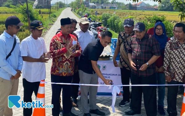 Foto Anggota DPRD Sidoarjo dari Partai Gerindra Pratama Yudhiarto menggunting pita peresmian jalan paving di Dusun Jumput Kulon, Desa Jumputrejo, Sukodono. (Foto: Fathur Roziq/Ketik.co.id)