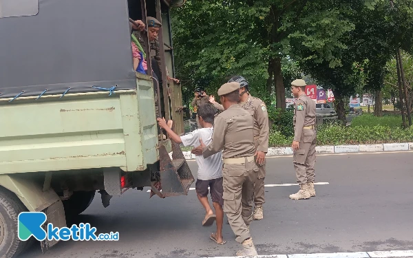 Foto Seorang anak yang kedapatan mengemis di Jalan Bypass Juanda dibawa petugas ke truk Satpol PP Sidoarjo. (Foto: Fathur Roziq/Ketik.co.id)