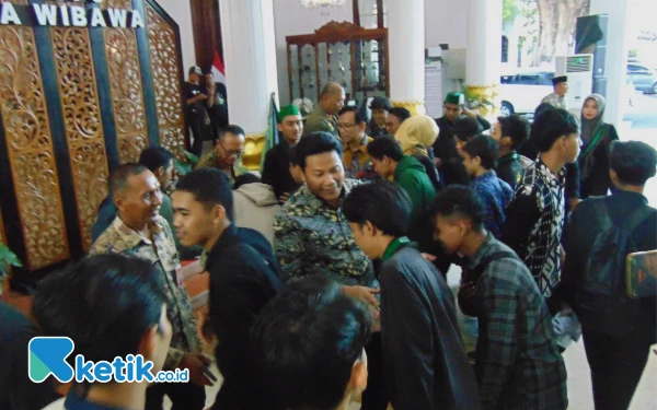 Foto Bupati Subandi dan para mahasiswa saling bersalaman, lalu berfoto bersama setelah unjuk rasa dan audiensi selesai. (Foto: Fathur Roziq/Ketik.co.id)