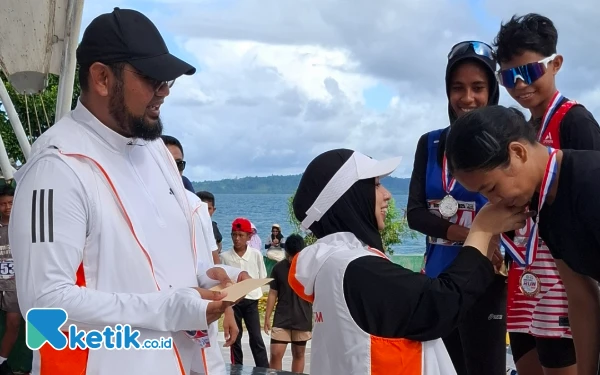 Thumbnail Ketua TP-PKK Rifa’at Al-Sa’adah Bassam mengalungi medali ke juara lomba lari 10 kilo meter puteri Minggu 8 Juni 2025. (Foto: Mursal/Ketik.co.id)
