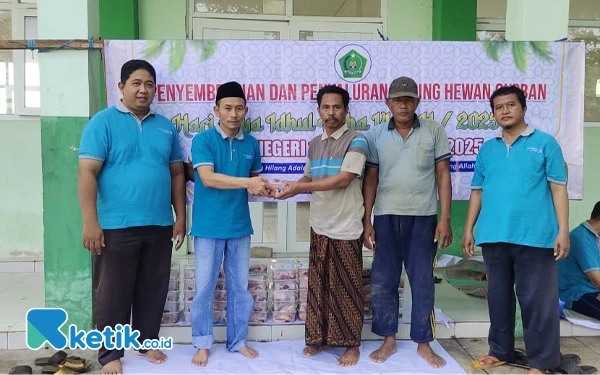 Thumbnail Matrapi Kepala MTsN 1 Sampang saat menyerahkan daging kurban kepada warga sekitar sekolah, Senin, 9 Juni 2025 di depan Sekolah MTsN 1 Sampang (Foto: Mat Jusi/Ketik.co.id).