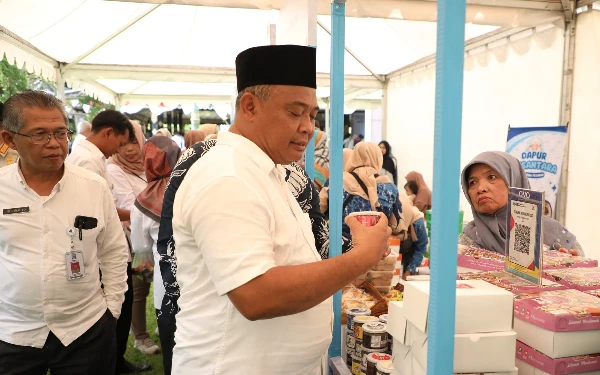 Foto Bupati Sleman Harda Kiswaya (pakai peci) saat meninjau sejumlah stand dalam acara temu pelaku usaha Mbizmarket di seputaran Pendopo Parasamya Kabupaten Sleman. (Foto: Prokopim Sleman/Ketik)