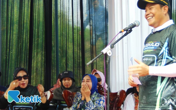 Foto Bupati Subandi menyampaikan pujian kepada istrinya, dr Sriatun Subandi, saat membuka acara drag bike street race di Jabon pada Sabtu, 24 Mei lalu. Wabup Mimik Idayana pun ikut tertawa. (Foto: Fathur Roziq/Ketik.co.id)