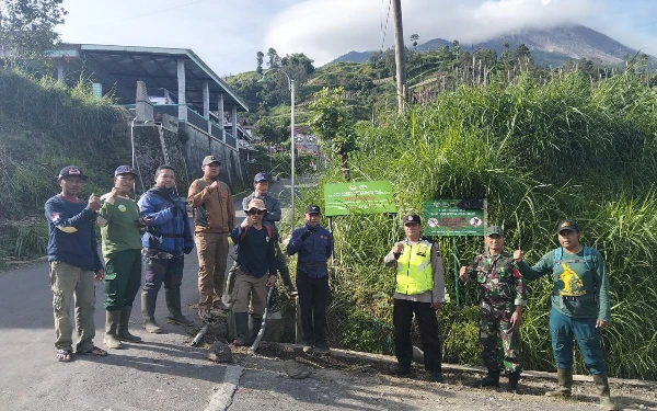 Foto Disela melakukan penjagaan. Sejumlah petugas berfoto bersama didepan papan informasi larangan pendakian di Gunung Merapi di New Selo, Boyolali. (Foto: BTNGM/Ketik)
