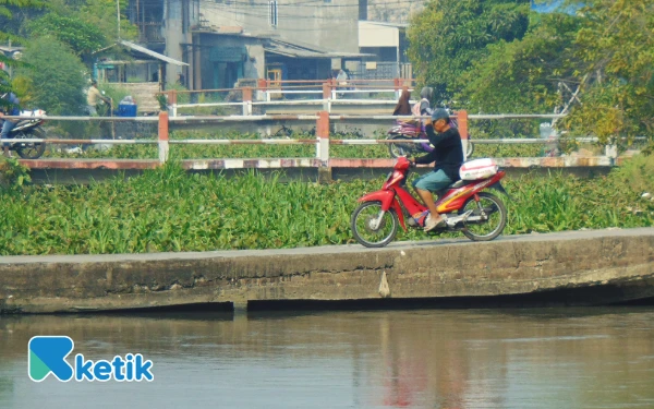 Foto Kondisi Kali Pelayaran di wilayah Desa Tanjungsari. Masih tertutup enceng gondok dan jembatan yang rendah. (Foto: Fathur Roziq/Ketik.co.id)