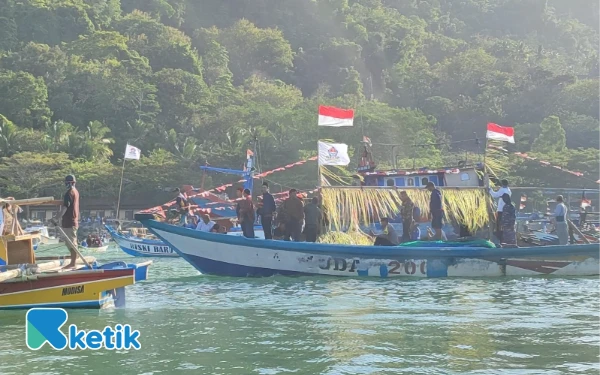 Foto Proses pelarungan sesaji ke tengah lautan yang diiringi arak-arakan kapal nelayan TPI Tamperan Pacitan, 18 Juli 2023. (Foto: Al Ahmadi/Ketik)
