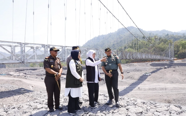 Foto Gubernur Khofifah berbincang dengan Pj Bupati Lumajamg dan anggota Forkopimda dengan latar belakang Jembatan Gantung Kaliregoyo. (Foto: pemprov Jatim)