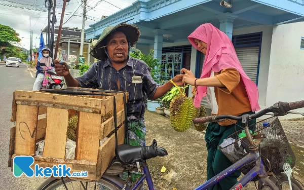 Foto Boradi tengah melayani pembelian durian dagangannya. (Foto: Al Ahmadi/Ketik.co.id)