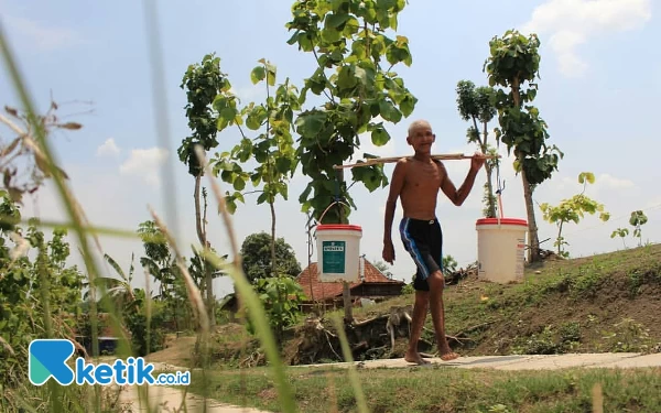 Foto Seorang kepala keluarga tengah menuju mbelik, demi mendapatkan seteguk air bersih untuk kebutuhan keluarga. (Foto: Dok. Ketik.co.id)